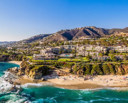 Laguna Beach coastline with sandy coves and hillside buildings.